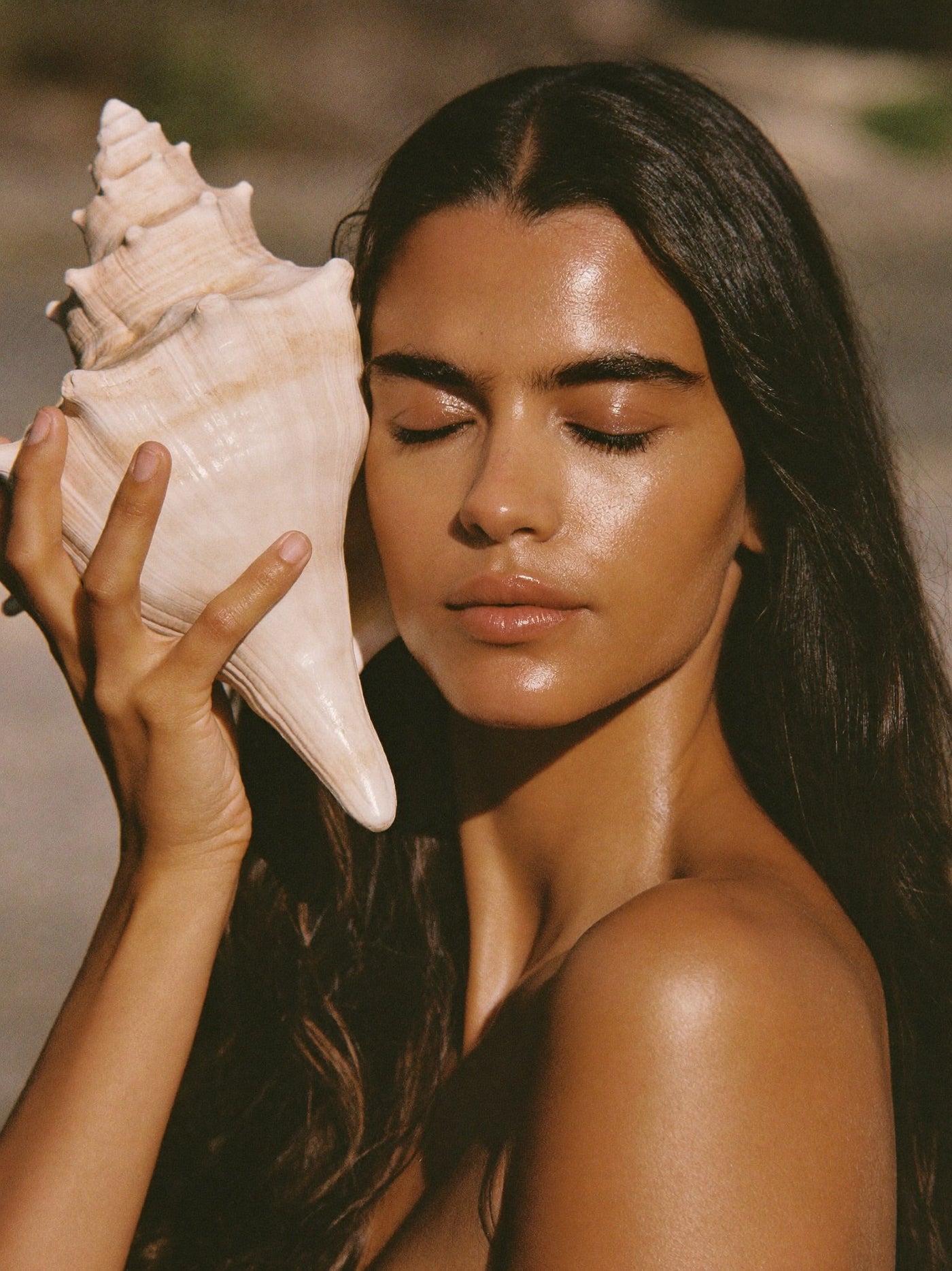 Woman holding a conch shell beside her face, Face Lightening and Brightening Packages at Pink Laser Clinics