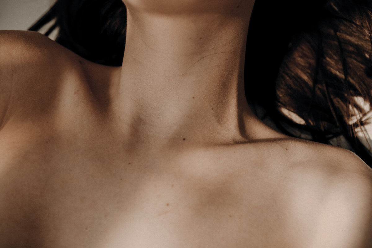 Clean neck and collarbone in natural light, considering removal of a confirmed-benign mole.