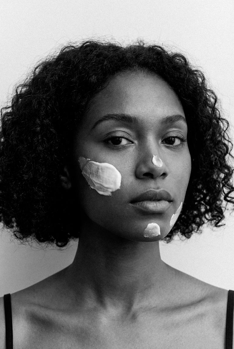 Editorial portrait of a woman with deep skin tone and a clear, even complexion.