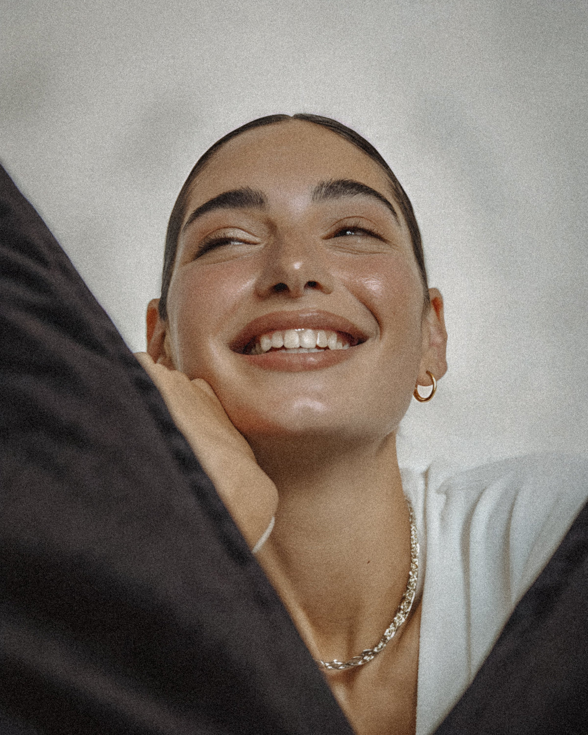 Editorial portrait of a woman laughing with genuine warmth in soft natural light.