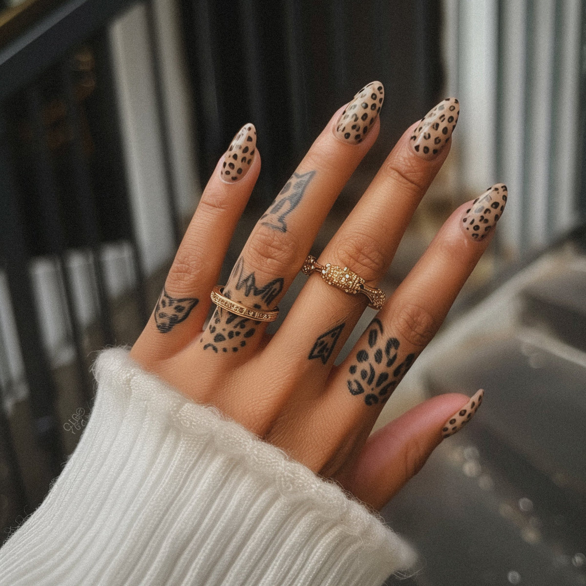 A hand with fine finger tattoos and rings. Small, delicate work has its own sensation profile.