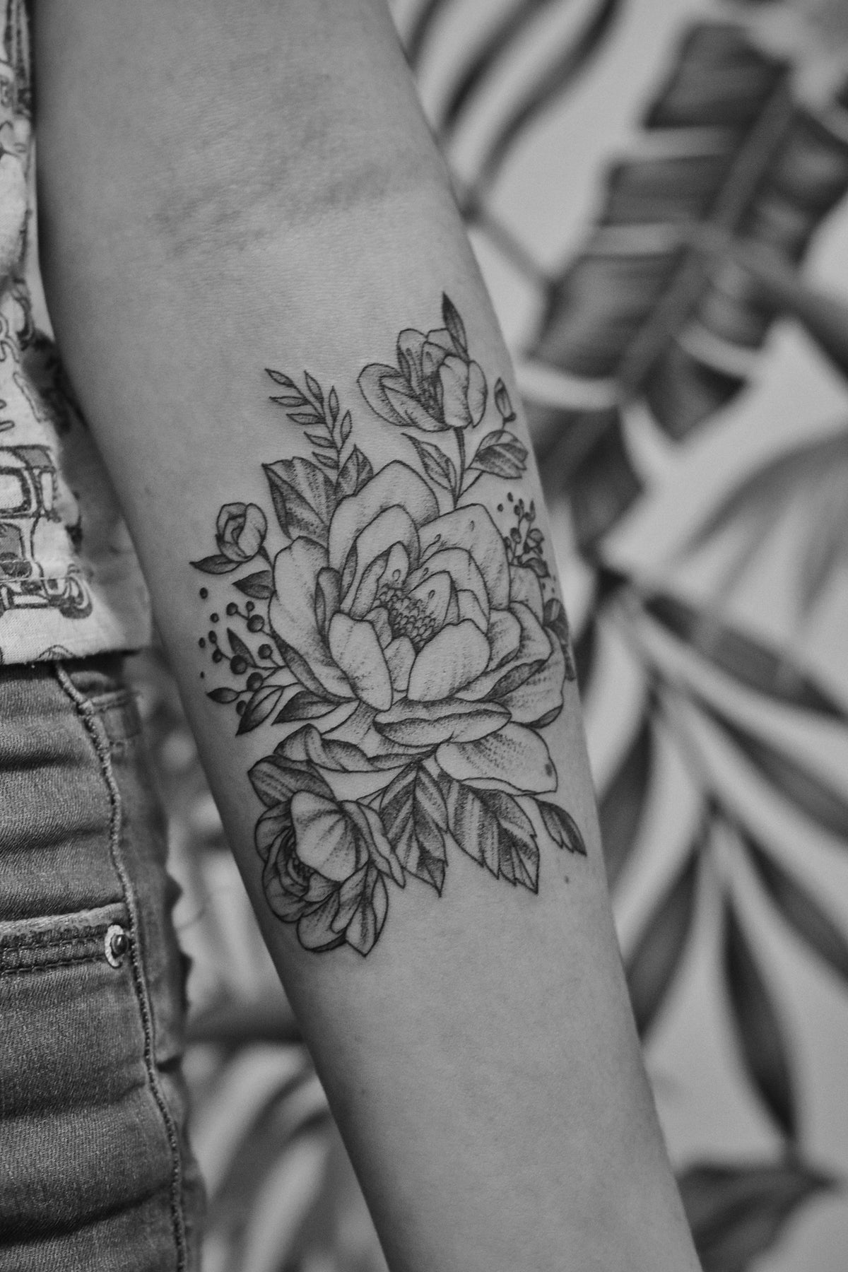 A bold floral tattoo on a forearm, the kind of piece clients ask whether laser can fully erase.