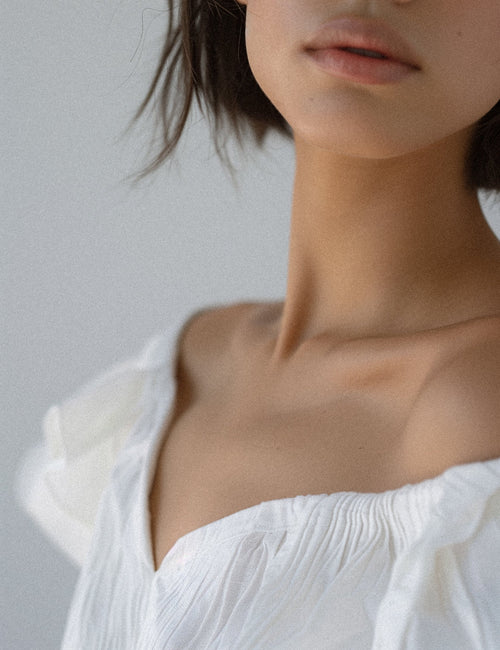Close-up of periorbital skin showing fine lines at the eye corner, clinical lighting.