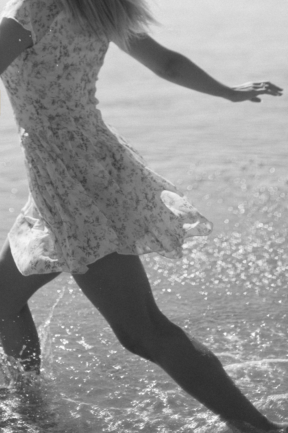 Figure moving freely through shallow water in bright light