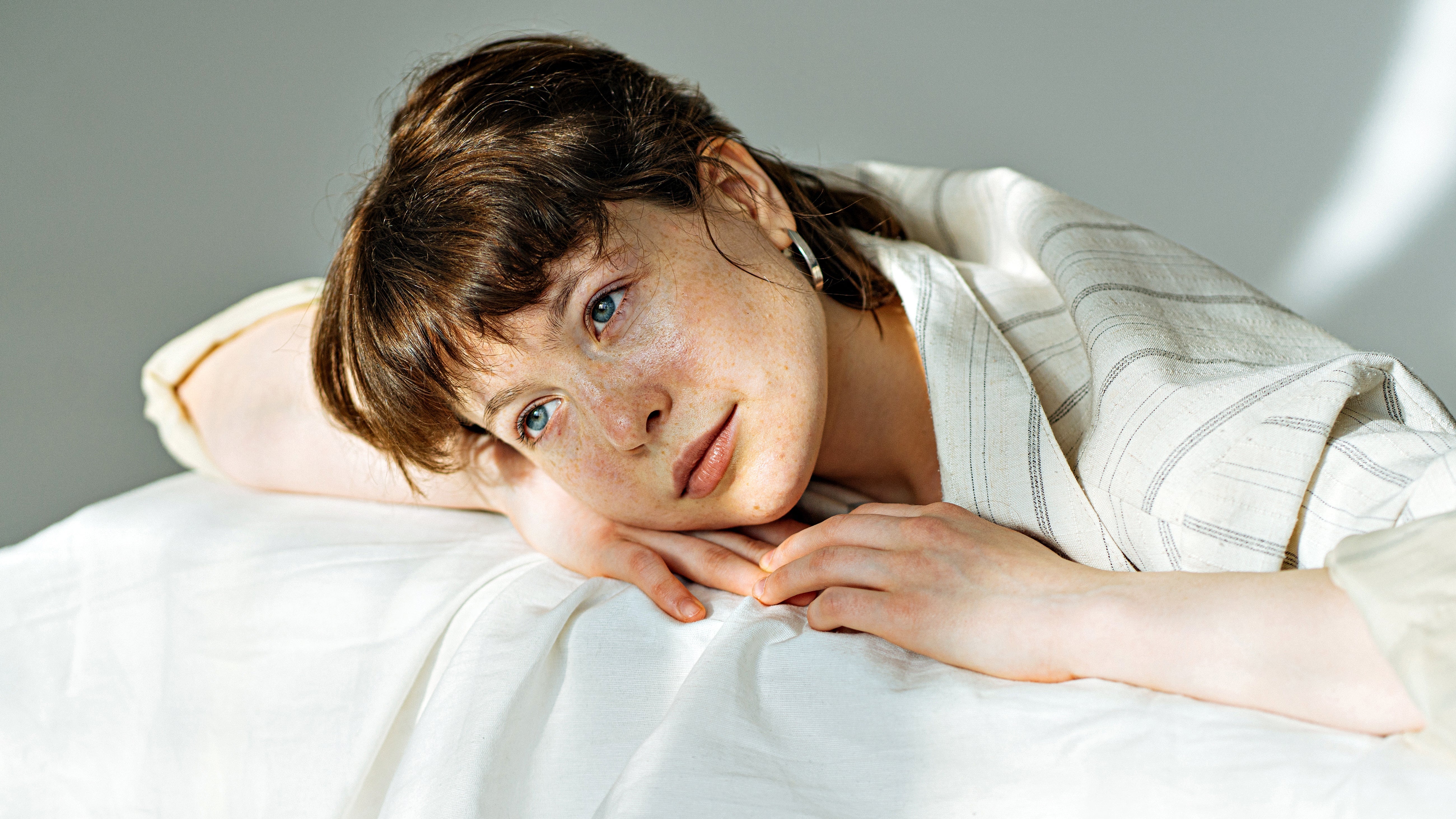 Close-crop editorial portrait in soft indirect light, representing specialist pigmentation treatment at Pink Laser Clinics.